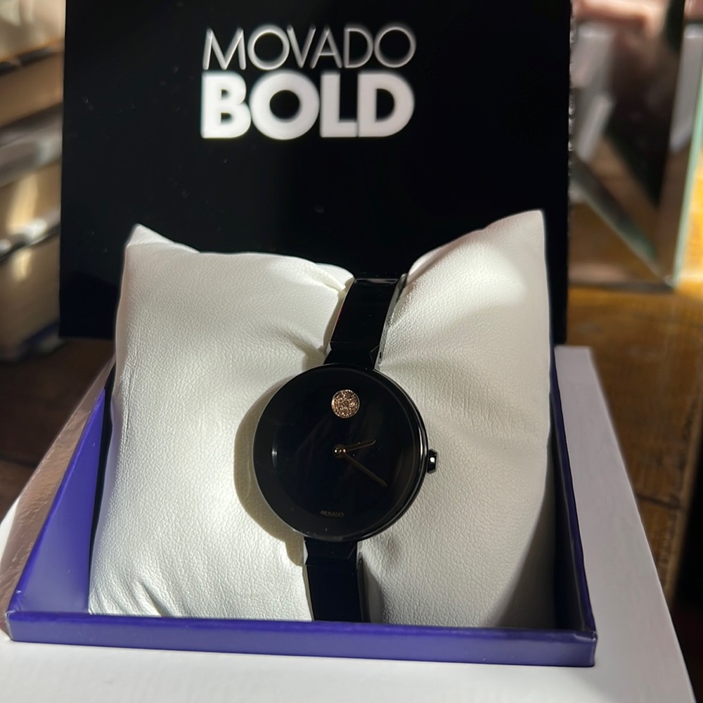 Movado bold black bangle watch with purple pearl face. Brand new in box